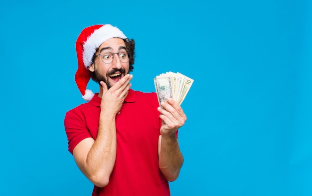 Young crazy bearded man with santa hat. Christmas concept