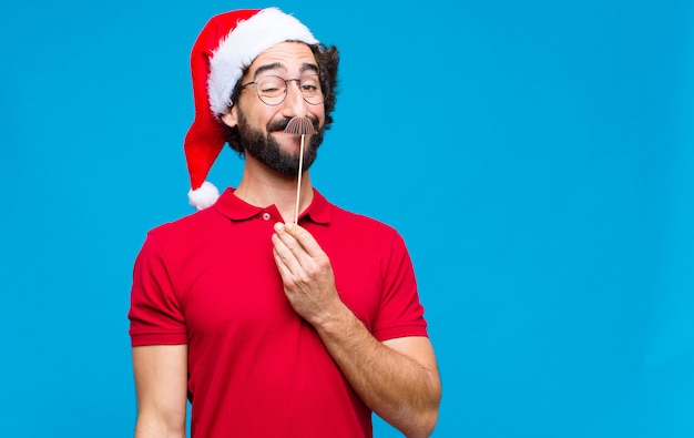 Young crazy bearded man with santa hat. Christmas concept