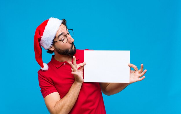 Young crazy bearded man with santa hat. Christmas concept