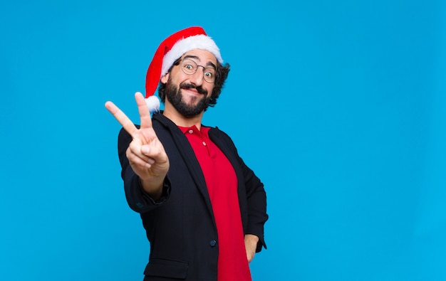 Young crazy bearded man with santa hat. Christmas concept