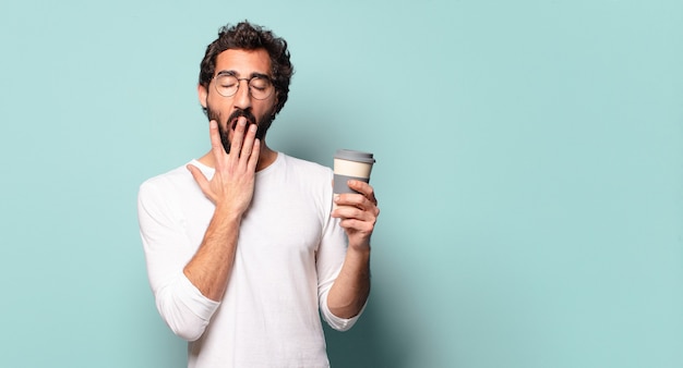 Giovane uomo barbuto pazzo con un caffè da asporto