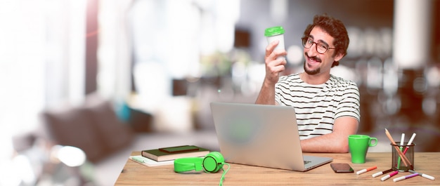 Young crazy graphic designer on a desk with a laptop 