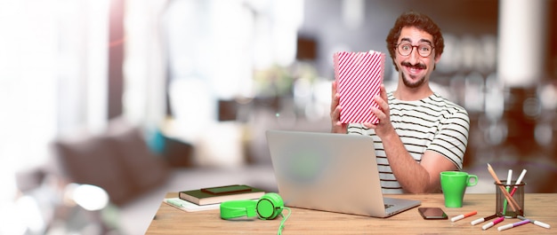 Young crazy graphic designer on a desk with a laptop 