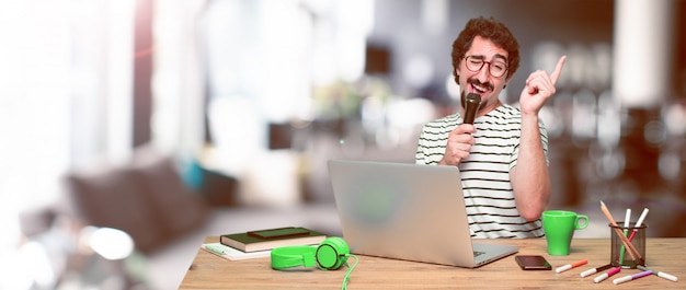 Young crazy graphic designer on a desk with a laptop