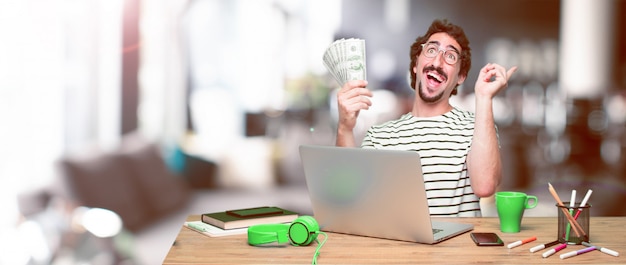 Young crazy graphic designer on a desk with a laptop 