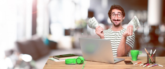 Young crazy graphic designer on a desk with a laptop