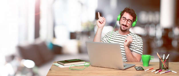 Young crazy graphic designer on a desk with a laptop 