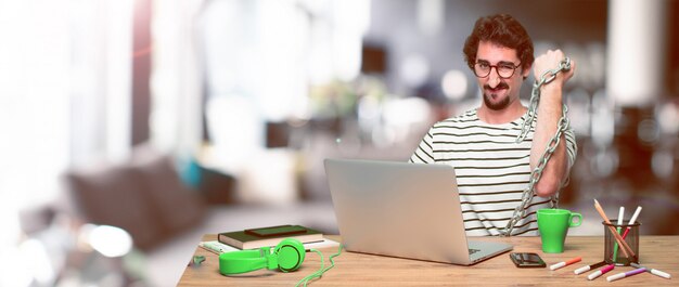 Young crazy graphic designer on a desk with a laptop 