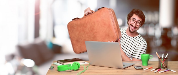 Young crazy graphic designer on a desk with a laptop 