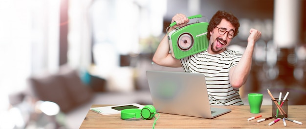 Young crazy graphic designer on a desk with a laptop 