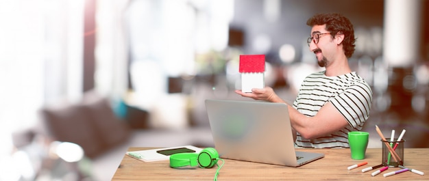 Young crazy graphic designer on a desk with a laptop 