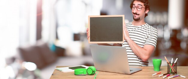 Young crazy graphic designer on a desk with a laptop 