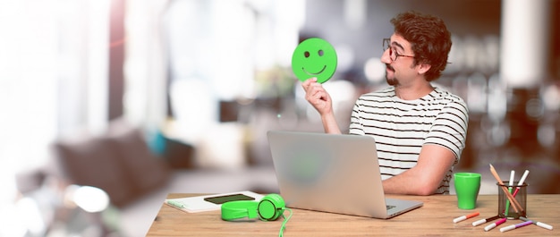 Young crazy graphic designer on a desk with a laptop 