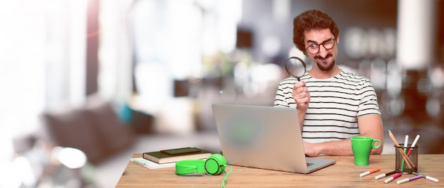 Young crazy graphic designer on a desk with a laptop