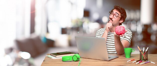 Young crazy graphic designer on a desk with a laptop 