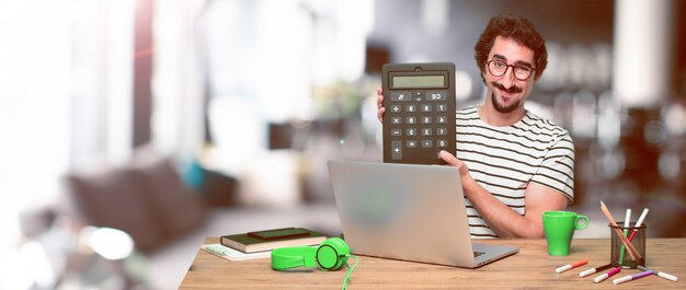 Young crazy graphic designer on a desk with a laptop 