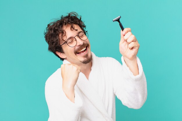 Young crazy man shaving his beard with a razor