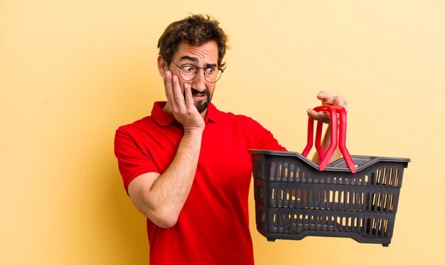 Young crazy man with a empty shopping basket