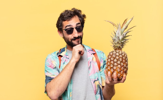 Young crazy traveler man thinking expression and holding a pineapple