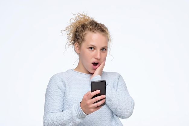 Young curly girl reading a message containing interesting news