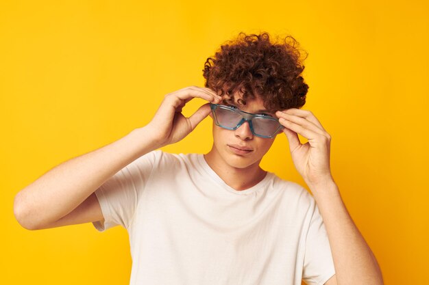 Young curly-haired man in blue glasses white t-shirt fashion modern style isolated background unaltered person