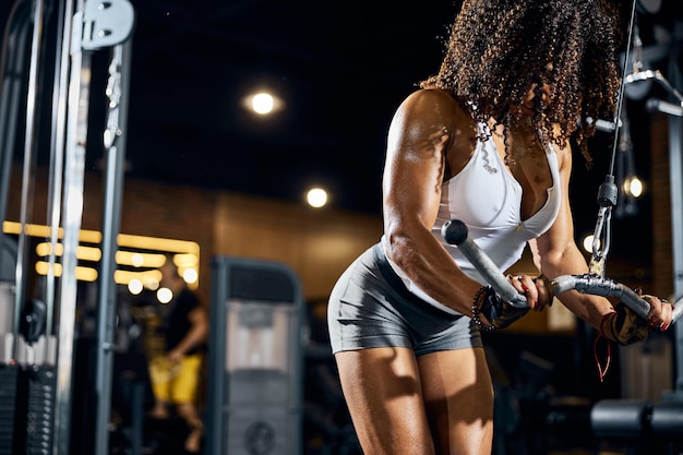 Photo young curly-haired woman strengthening her back muscles