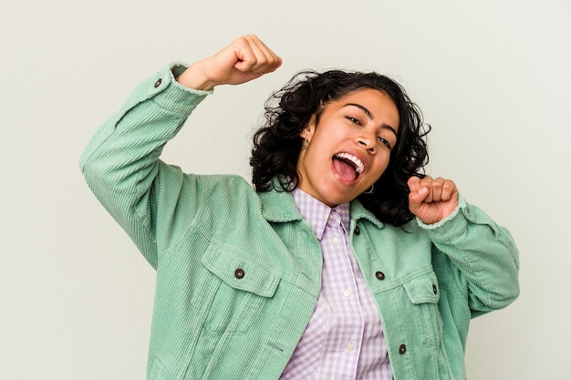 Photo young curly latin woman isolated on white background raising fist after a victory, winner concept.