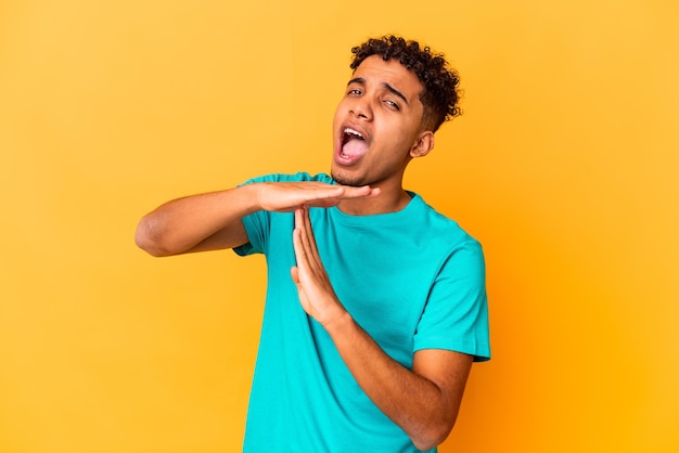 Young curly man isolated showing a timeout gesture