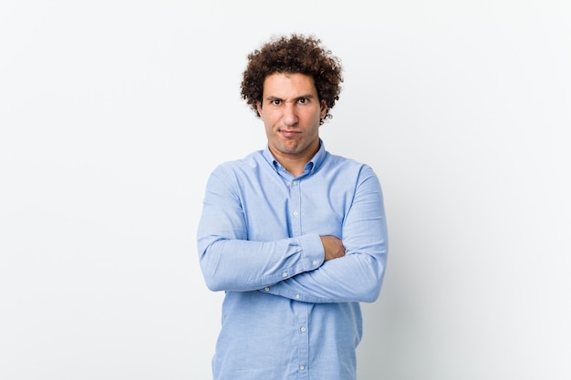 Young curly mature man wearing an elegant shirt frowning face in displeasure