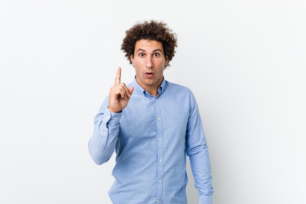 Young curly mature man wearing an elegant shirt having an idea