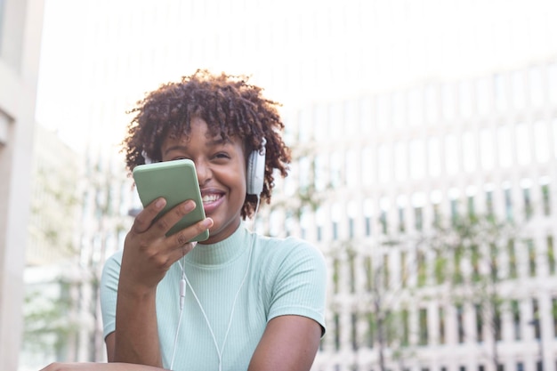 스마트폰으로 음성 메시지를 녹음하는 곱슬머리 젊은 여성 곱슬머리를 한 라틴 십대는 휴대전화를 녹음기로 사용하여 어머니에게 음성 메시지를 보냅니다.