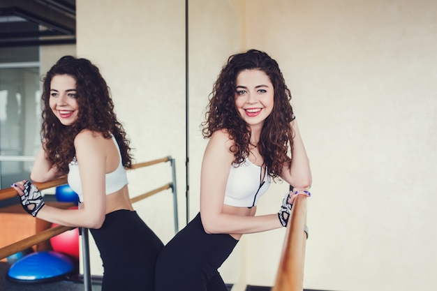 Young curly woman resting at the gym