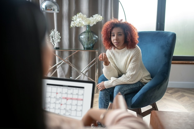 Photo young curly woman talking to her psychotherapist