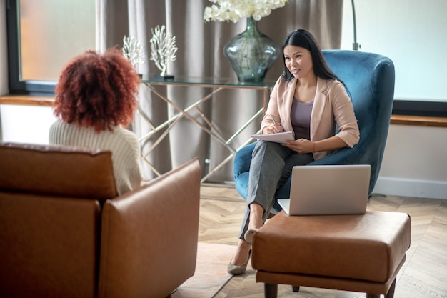 Photo young curly woman talking to her psychotherapist