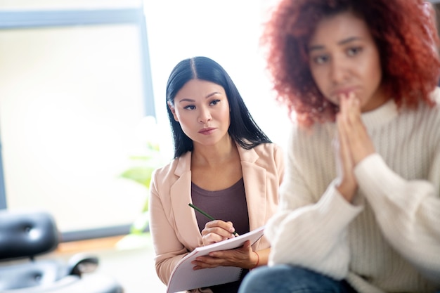 Young curly woman talking to her psychotherapist