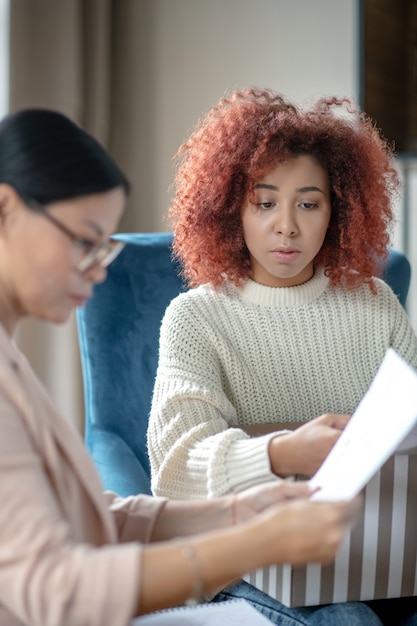 Photo young curly woman talking to her psychotherapist