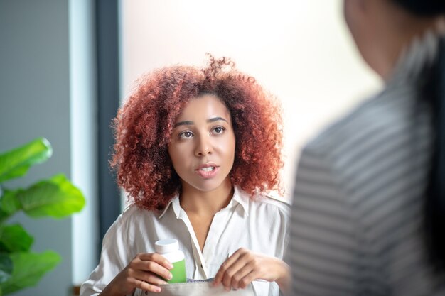 Photo young curly woman talking to her psychotherapist