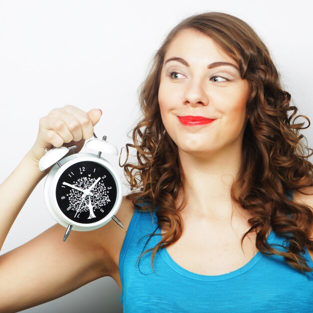 Young curly woman with alarmclock