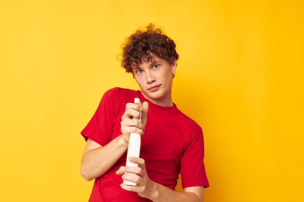 Young curlyhaired man detergent posing emotion yellow background unaltered