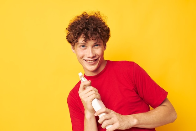 Young curlyhaired man detergents home care posing isolated background unaltered