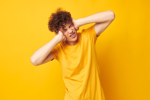 Young curlyhaired man youth style studio casual wear yellow background unaltered