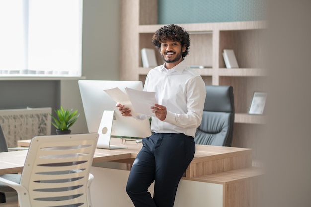 Giovane manager dai capelli ricci che si sente impegnato al lavoro