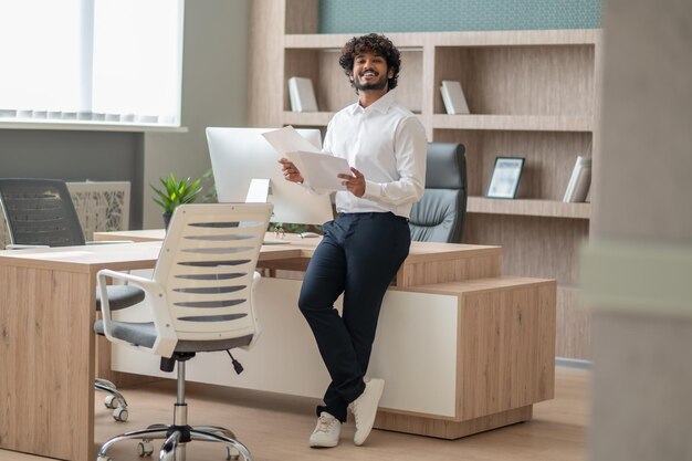 Giovane manager dai capelli ricci che si sente impegnato al lavoro