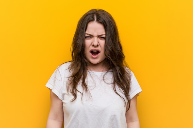 Young curvy plus size woman screaming very angry and aggressive.