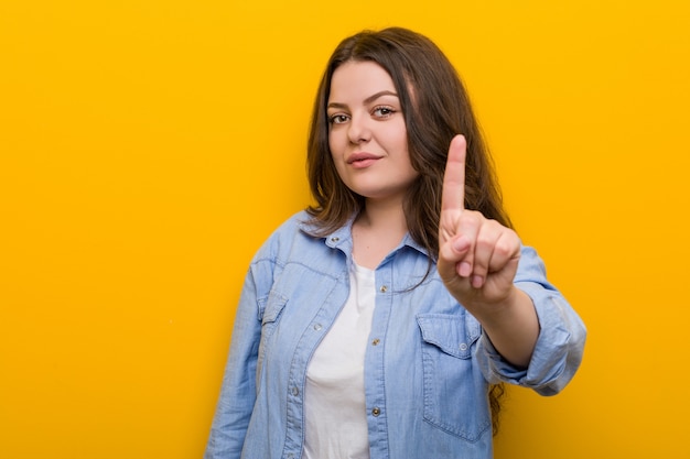 Photo young curvy plus size woman showing number one with finger.