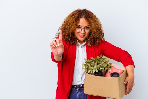 Young curvy woman moving to a new home isolated on white background showing number one with finger.