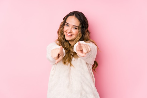 Young curvy woman posing in pink