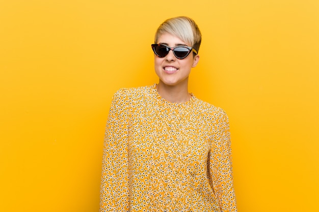 Young curvy woman wearing a floral summer clothes happy, smiling and cheerful.