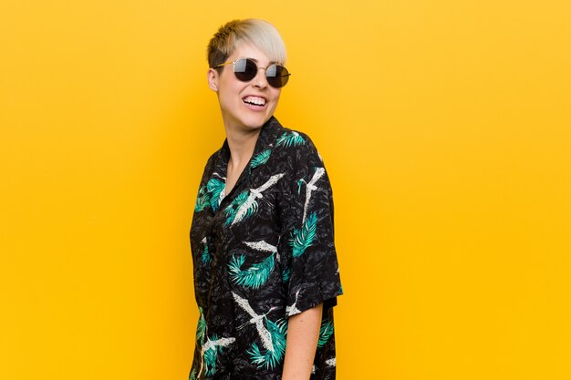 Young curvy woman wearing a summer look looks aside smiling, cheerful and pleasant.