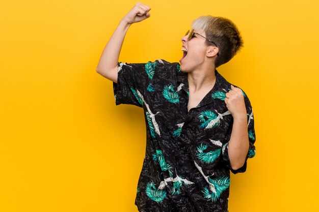 Young curvy woman wearing a summer look raising fist after a victory, winner concept.